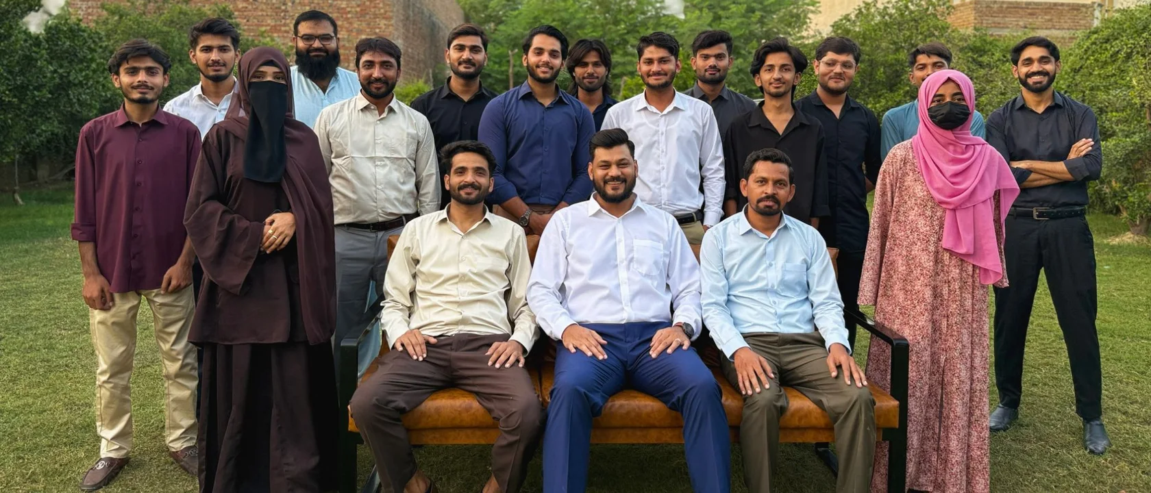 The Digital Vikingz team in a formal group photo on the lawn, three seated on the bench with the rest standing behind